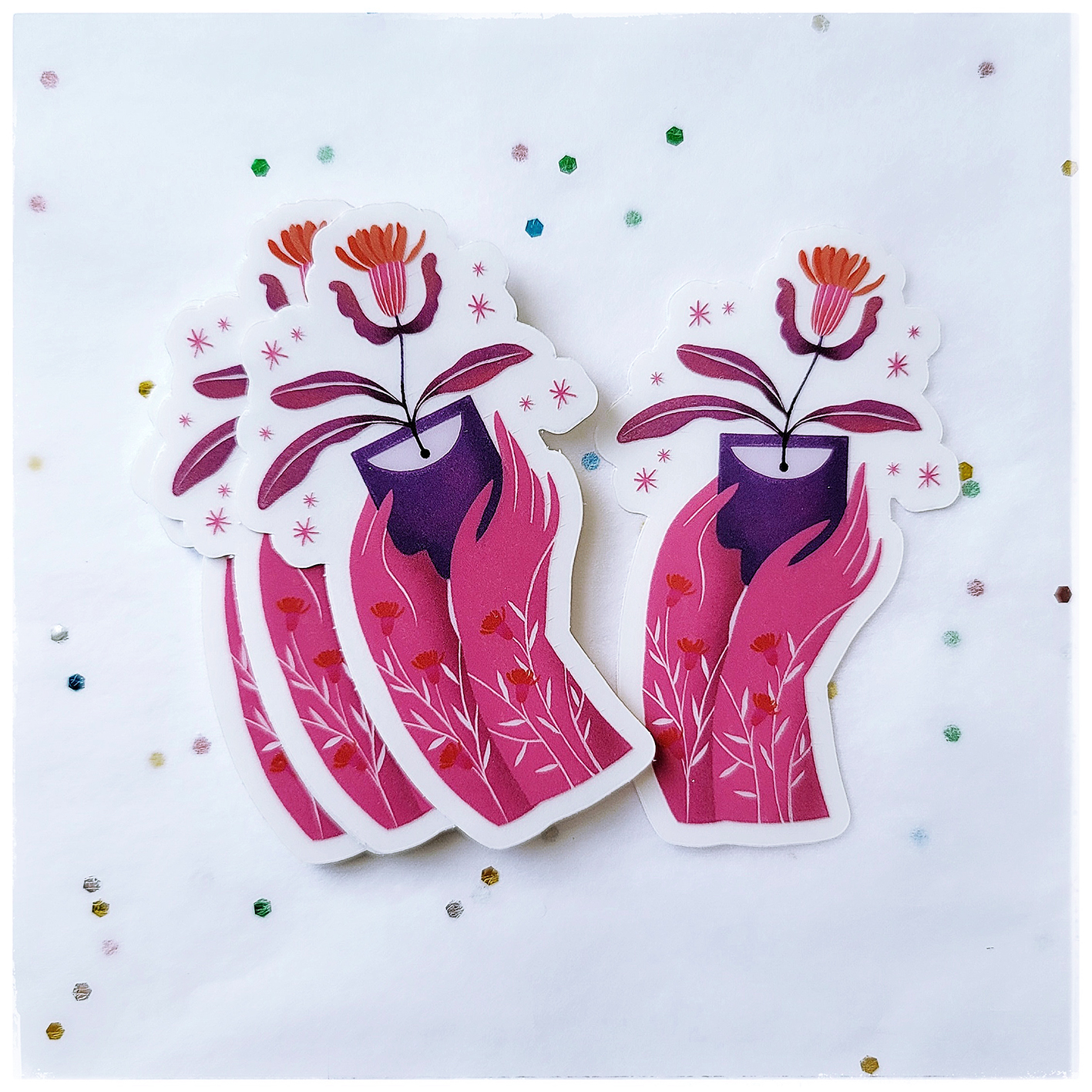 Clear vinyl sticker that showing two pink hands that are offering a red flower in a lovely manner. Both hands are covered with white and red tiny flowers. This sticker is water and weather proof.